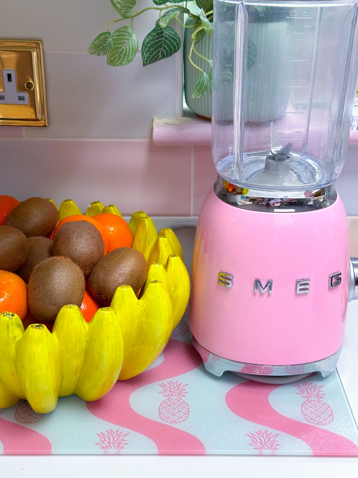 glass worktop saver with pineapple design in pink colour