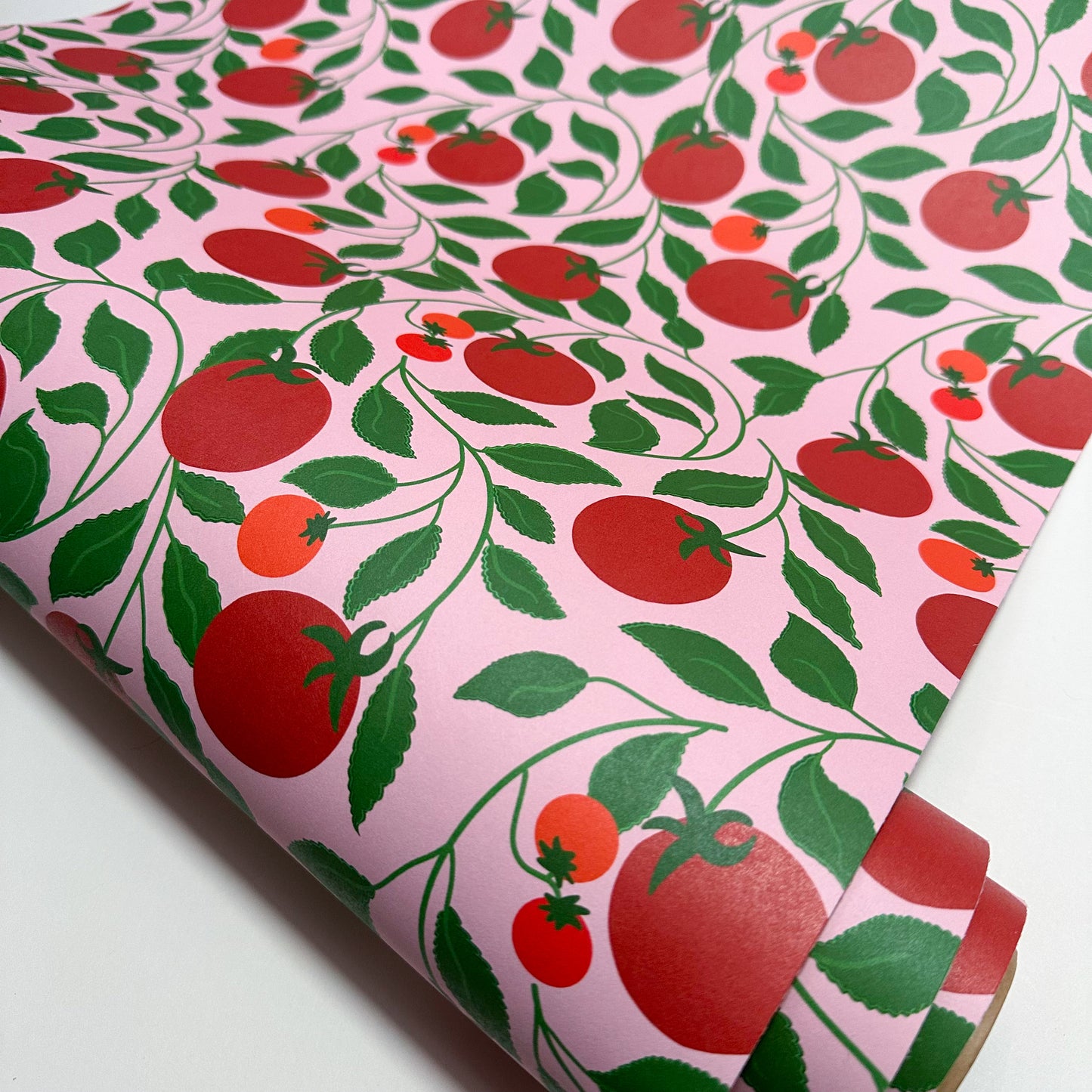 Roll of wallpaper with red tomato pattern on a pink background, quirky kitchen restaurant cafe wallpaper