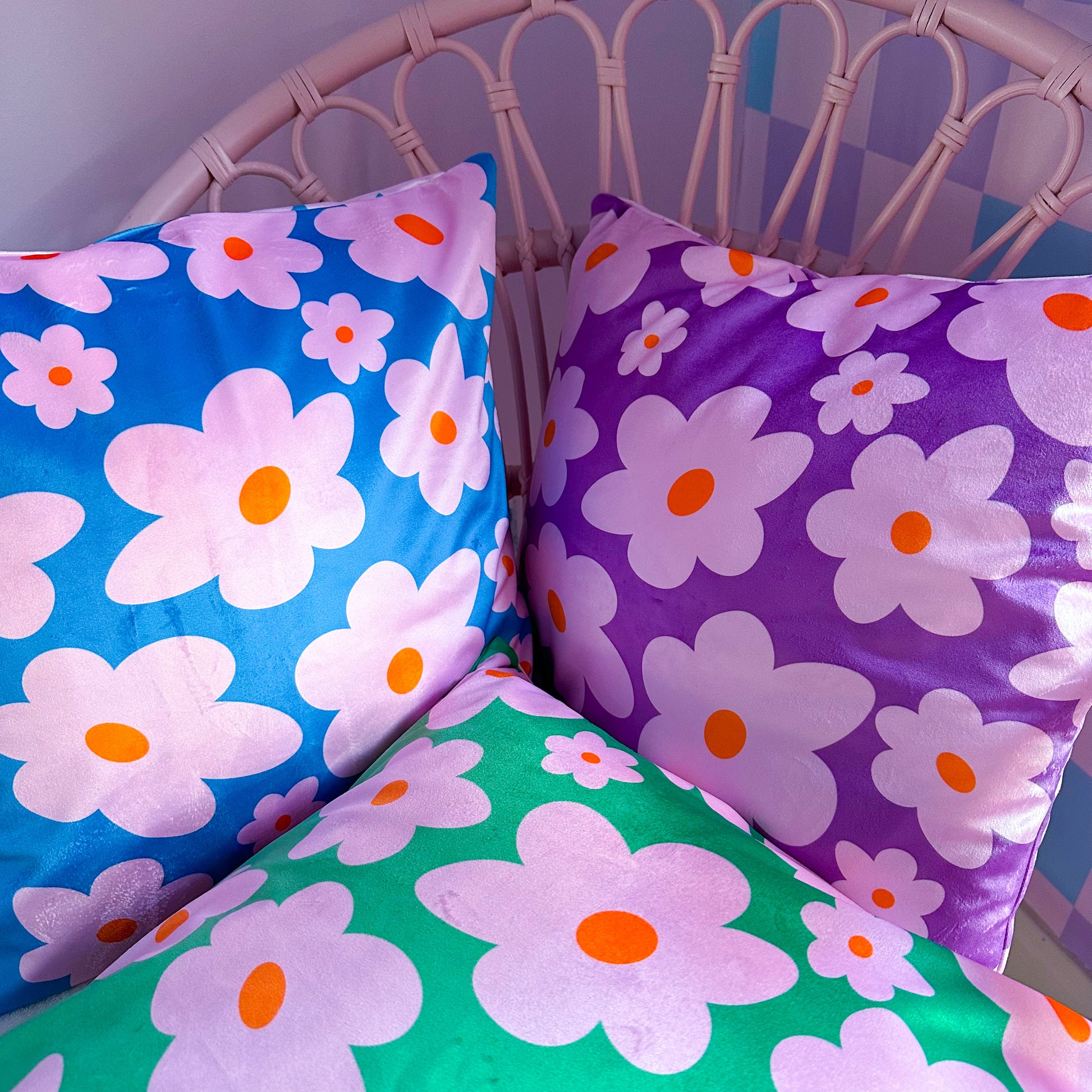 daisy cushions made from velvet material in purple, pink, blue and green colours