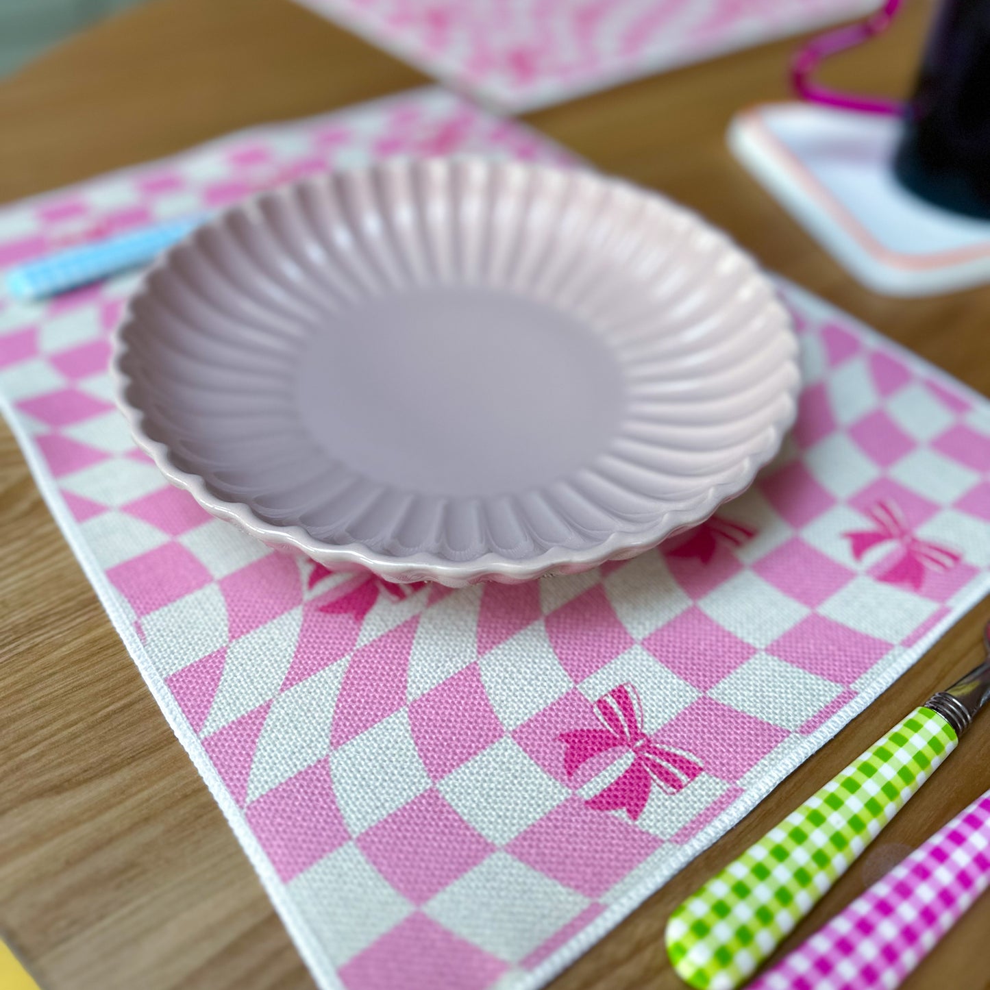 Linen placemat with ribbons and checkered design in pink colour 