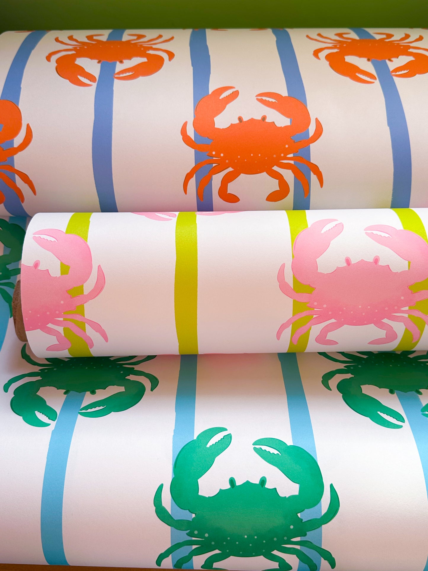 Three rolls of paper with crab designs on striped backgrounds.