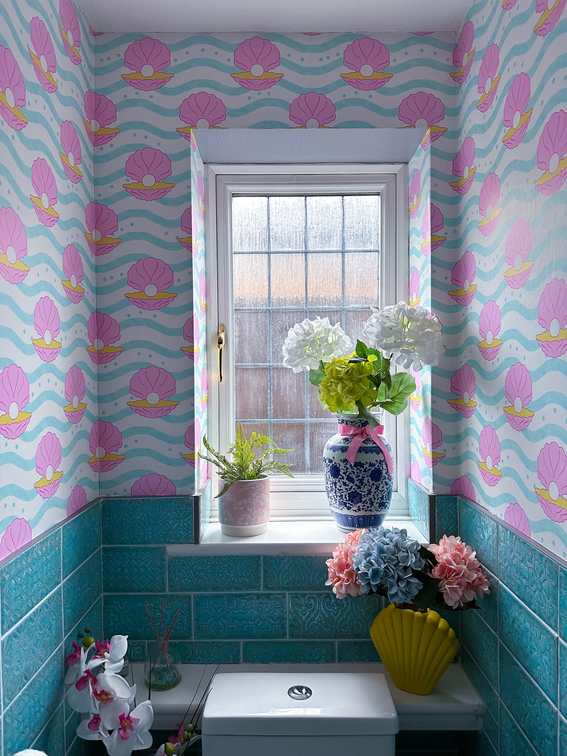 Bathroom wallpaper with clam shells in blue pink and yellow 