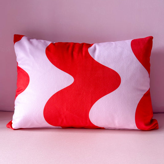 Red and pink velvet cushion with wavy abstract design 